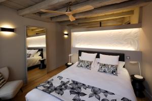 a bedroom with a large white bed with pillows at Les Maisons du Pont - Charme & Caractère in Aubusson