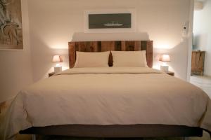 a bedroom with a large white bed with two lamps at Les Pins de l'Escalet in Ramatuelle