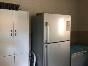 a kitchen with a white refrigerator and cabinets at Villa case authentique , in Saly Portudal
