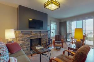 a living room with a fireplace and a tv at Seasons at Sandpoint in Sandpoint