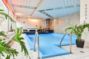 a swimming pool in a building with plants at Bavaria Hotel in Ingolstadt