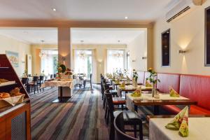 un comedor con mesas y sillas en un restaurante en Bavaria Hotel en Ingolstadt