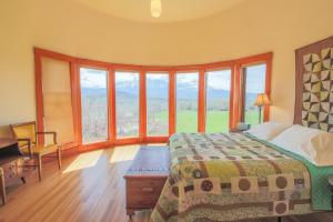 een slaapkamer met een bed en grote ramen bij Wisehart Springs Inn in Paonia