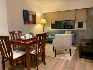 a living room with a table and chairs and a couch at URBANA APARTMENTS 413 in San Carlos de Bariloche