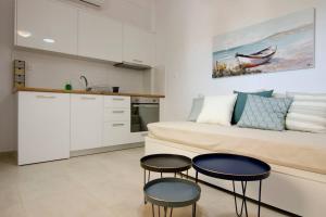 uma cozinha e sala de estar com um sofá e duas mesas em Giorgos villa em Palekastron