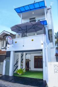a white house with a blue roof at Elsy Villa Negombo in Negombo