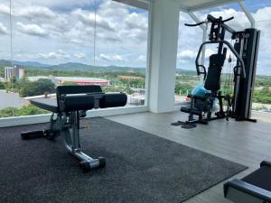 un gimnasio con dos máquinas de correr en una habitación con una gran ventana en Crystal Hotel Hat Yai, en Hat Yai