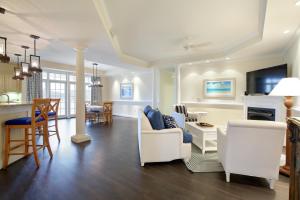 a living room with white furniture and a dining room at Waterside Resort by Capital Vacations in Edenton