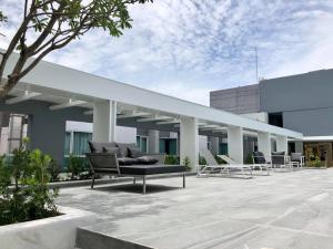 een gebouw met een bank en stoelen op een patio bij Crystal Hotel Hat Yai in Hat Yai