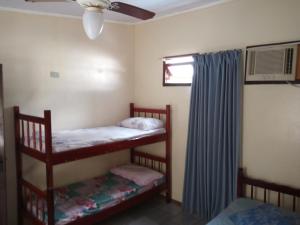 two bunk beds in a room with a ceiling fan at Pousada são Francisco do sul-SC in Sambaqui