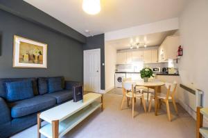 uma sala de estar com um sofá azul e uma mesa em ALTIDO Perfect Location! Charming Rose St Apt for Couples em Edimburgo