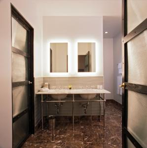 a bathroom with a sink, toilet and a mirror at Gild Hall - A Thompson Hotel in New York