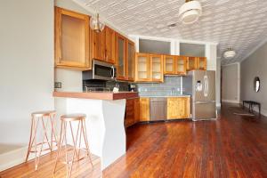 uma cozinha com armários de madeira e electrodomésticos de aço inoxidável em Sonder The Congress em Savannah