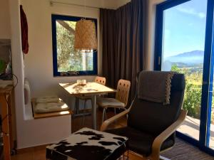 a living room with a table and a chair and a window at Landros in Kamilari