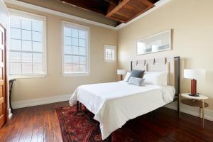 um quarto com uma cama branca e 2 janelas em Sonder The Congress em Savannah