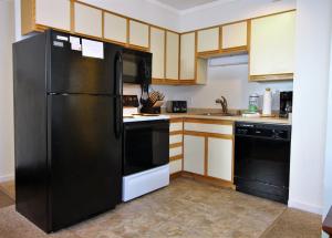 a kitchen with black appliances and wooden cabinets at Cozy three bedroom condo, Ski home Whiffletree I3 in Killington