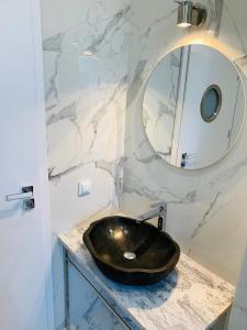 a bathroom with a black sink and a mirror at Apartament Pod Żaglami in Gdynia