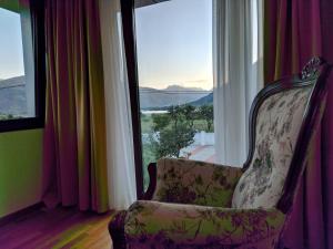 a chair sitting in a room with a large window at Apartments & Restaurant ABAS in Plav
