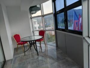 a table and chairs in a room with a window at Apartments & Restaurant ABAS in Plav