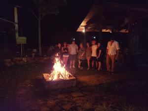 a group of people standing around a fire pit at night at Honduyate in Las Marías