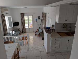 cocina y sala de estar con mesa y sofá en Anthoula's Sea View Apartment en Piso Livadi