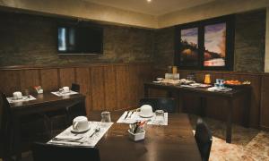 a dining room with tables and chairs and a television at Hotel Rural La Guaja in Puebla de Sanabria
