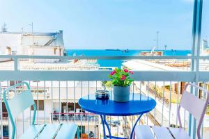 een blauwe tafel met een plant op een balkon bij Vintage Art home on the sea in Thessaloniki
