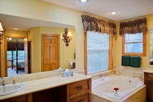 baño grande con bañera y lavamanos en Beaver Lake Cottages, en Eureka Springs