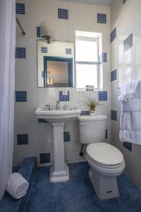 a blue and white bathroom with a toilet and a sink at Hollywood Beach Suites and Hotel in Hollywood