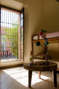 una habitación con una mesa y una ventana con una flor en un jarrón en Maria Bonita, en Guadalajara