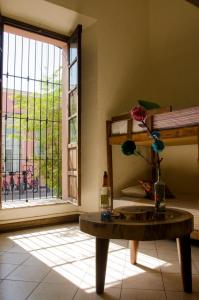 a room with a table and a window with a flower in a vase at Maria Bonita in Guadalajara