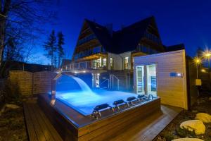 a house with a swimming pool at night at Nowy komfortowy Apartament & Spa Grizzly de lux in Zakopane