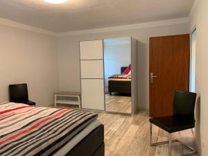 Schlafzimmer mit einem Bett und einem Spiegel in der Unterkunft Elbe Ferienwohnung Glückstadt in Glückstadt