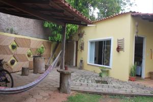 a patio with a hammock in front of a house at Hostel Luz in Anchieta