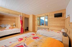 a bedroom with two beds and a flat screen tv at Au Bivouac de Napoléon et Spa in Bourg-Saint-Pierre