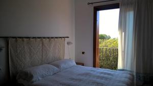a bedroom with a bed and a large window at Arcamyrtus in Alghero