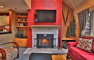 a living room with a fireplace with a tv above it at Cozy,1 bedroom loft condo! Ski back trails, shuttle& Sports center Highridge E11 in Killington