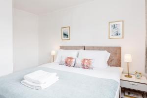 a white bedroom with a bed with white sheets and pillows at *CONTRACTOR *VACATION HOME* -THURROCK OCKENDON in South Ockendon