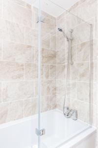 a shower with a glass door in a bathroom at *CONTRACTOR *VACATION HOME* -THURROCK OCKENDON in South Ockendon