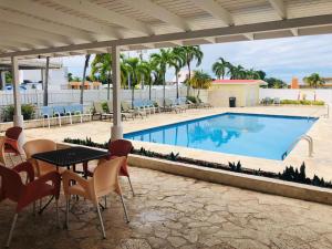 a patio with a table and chairs next to a swimming pool at Arecibo Inn in Arecibo