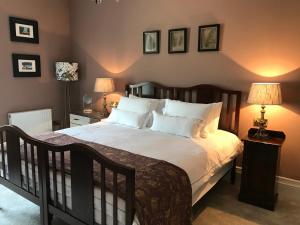 um quarto com uma cama grande e almofadas brancas em Rathaspeck Manor B&B em Wexford