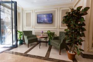 a waiting room with chairs and a table and a tv at Villa Sweet Hotel in Istanbul