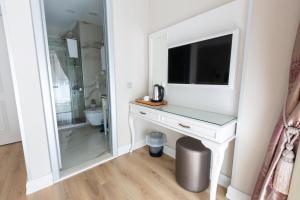a bathroom with a white desk with a tv and a mirror at Villa Sweet Hotel in Istanbul +18 photos