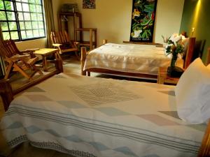 um quarto com uma cama, cadeiras e uma mesa em Pura Vida Hotel em Alajuela