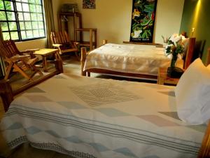 a bedroom with a bed and chairs and a table at Pura Vida Hotel in Alajuela City