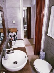 a bathroom with a white sink and a toilet at Superior Apartment in Korinthos