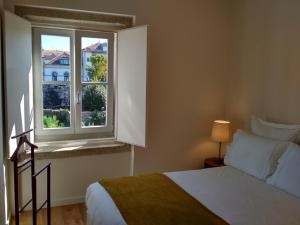 een slaapkamer met een bed en een raam bij Boavista Garden Apartment in Porto