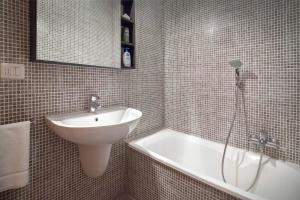 ein Badezimmer mit einem Waschbecken und einer Badewanne in der Unterkunft LA CHIARETTO SUITE in Bardolino