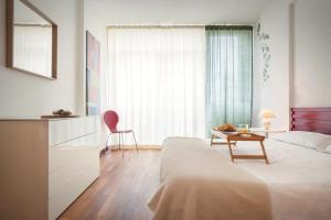 a bedroom with a bed and a table and a chair at LA CHIARETTO SUITE in Bardolino