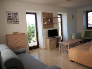 a living room with a couch and a tv at Apartament Nadmorski in Sarbinowo